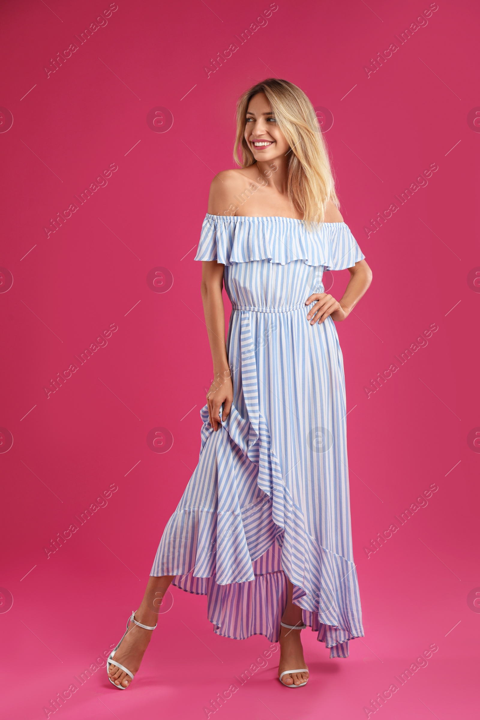 Photo of Young woman wearing stylish dress on pink background