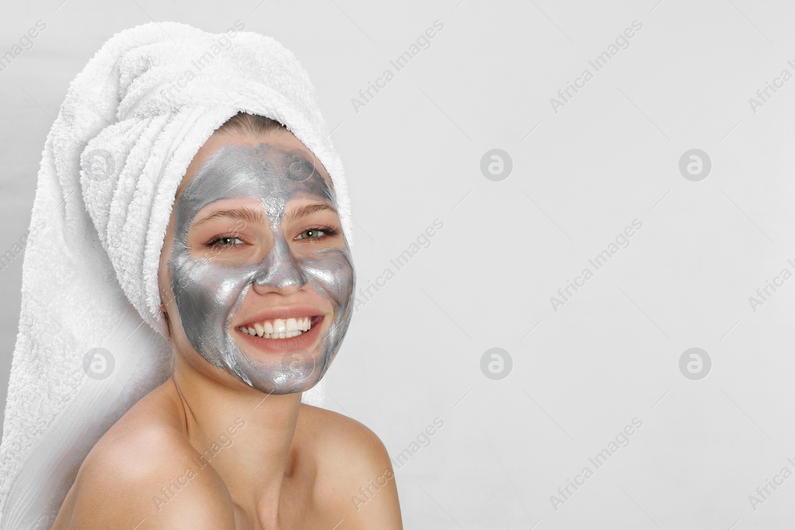 Photo of Beautiful woman with silver mask on her face against light background. Space for text