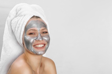 Photo of Beautiful woman with silver mask on her face against light background. Space for text