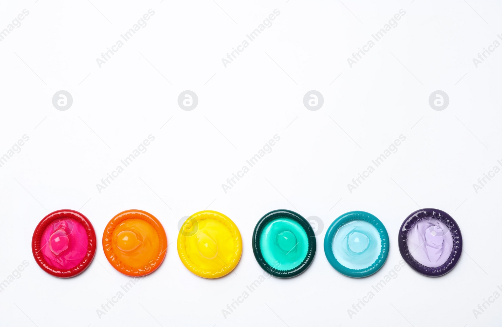 Photo of Colorful condoms on white background, top view. LGBT concept