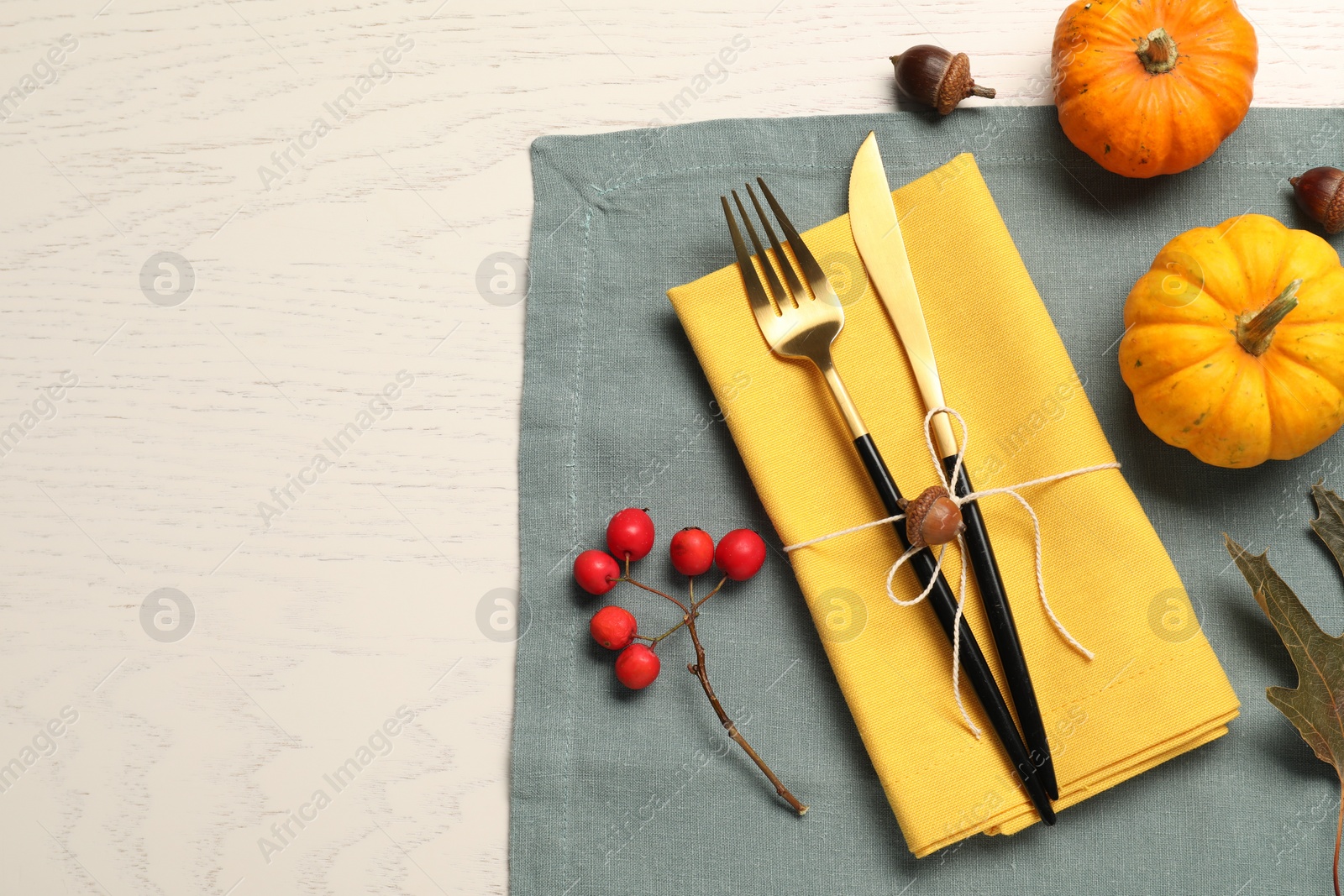 Photo of Cutlery, napkins and autumn decoration on white wooden background, flat lay with space for text. Table setting