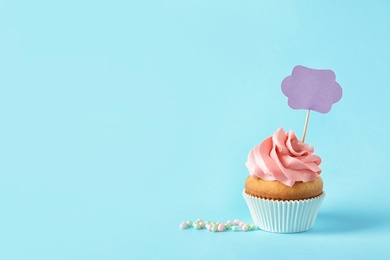 Photo of Delicious birthday cupcake and space for text on color background