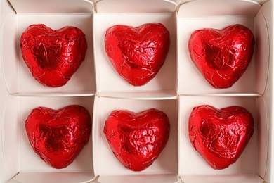 Photo of Tasty heart shaped chocolate candies in box, top view. Valentine's day celebration