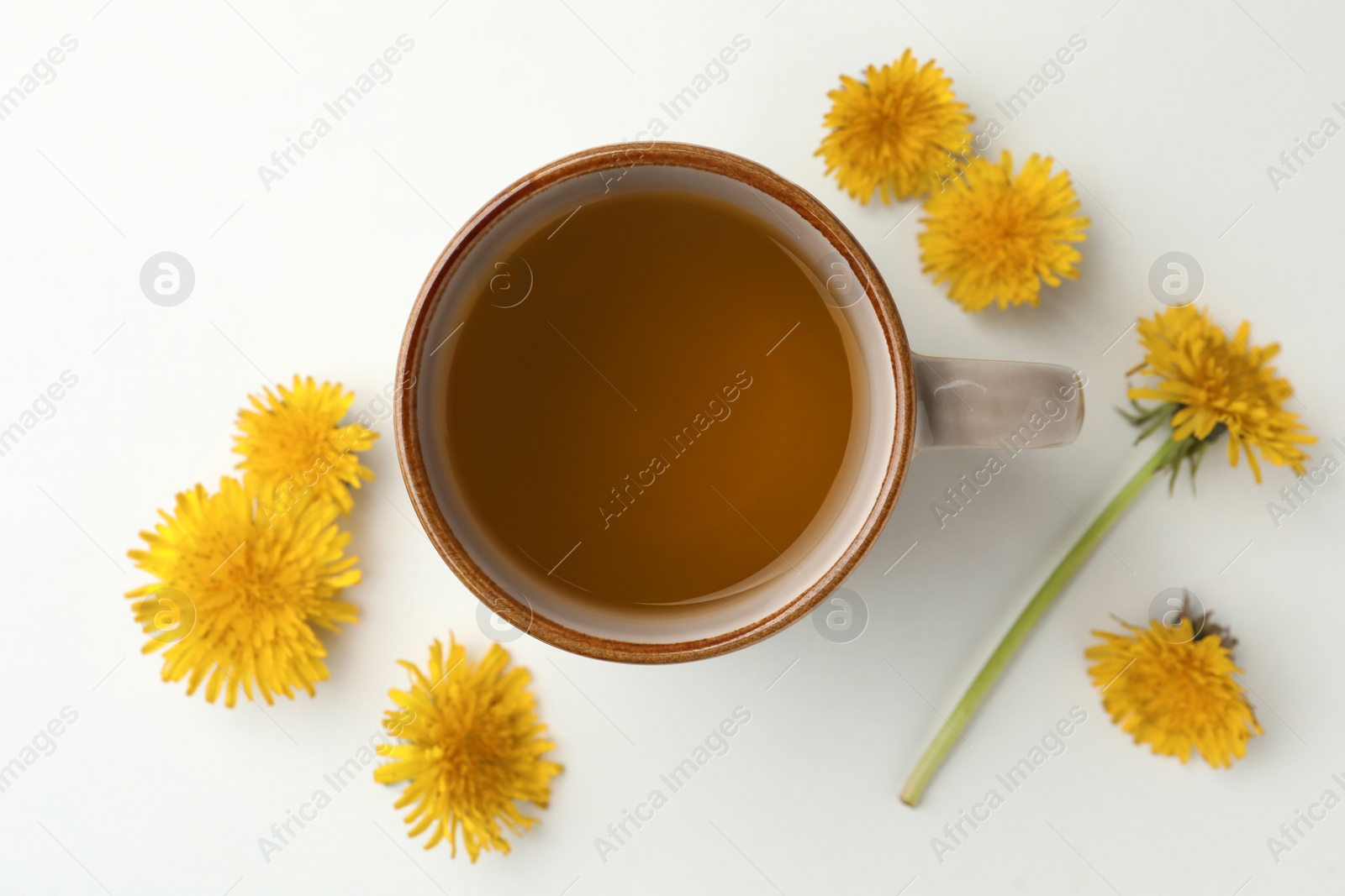 Photo of Delicious fresh tea and beautiful dandelion flowers on white background, top view