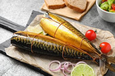 Photo of Tasty smoked fish served on grey table