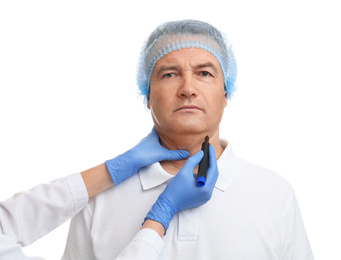 Photo of Surgeon with marker preparing man for operation against white background. Double chin removal