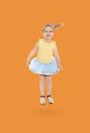Image of Happy cute girl jumping on orange background