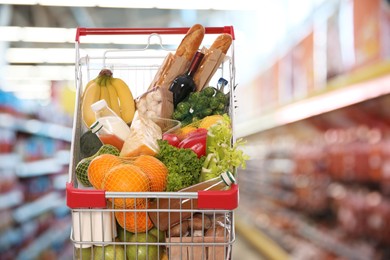 Image of Shopping cart with different groceries in supermarket