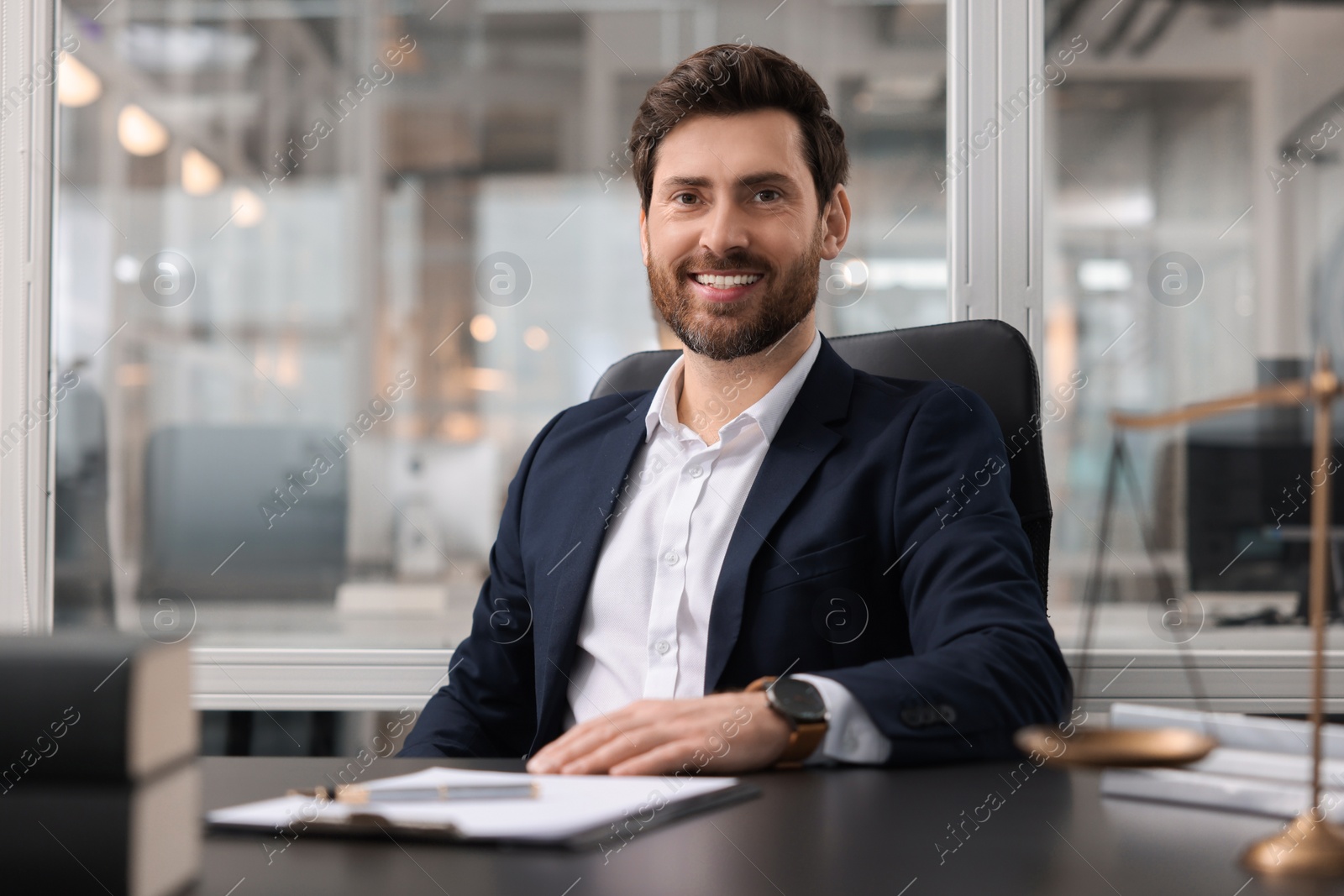 Photo of Portrait of smiling lawyer at table in office