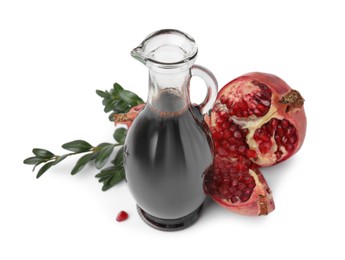 Photo of Tasty pomegranate sauce in bottle, fruits and branches isolated on white