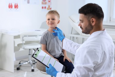 Photo of Endocrinologist examining thyroid gland of patient at hospital