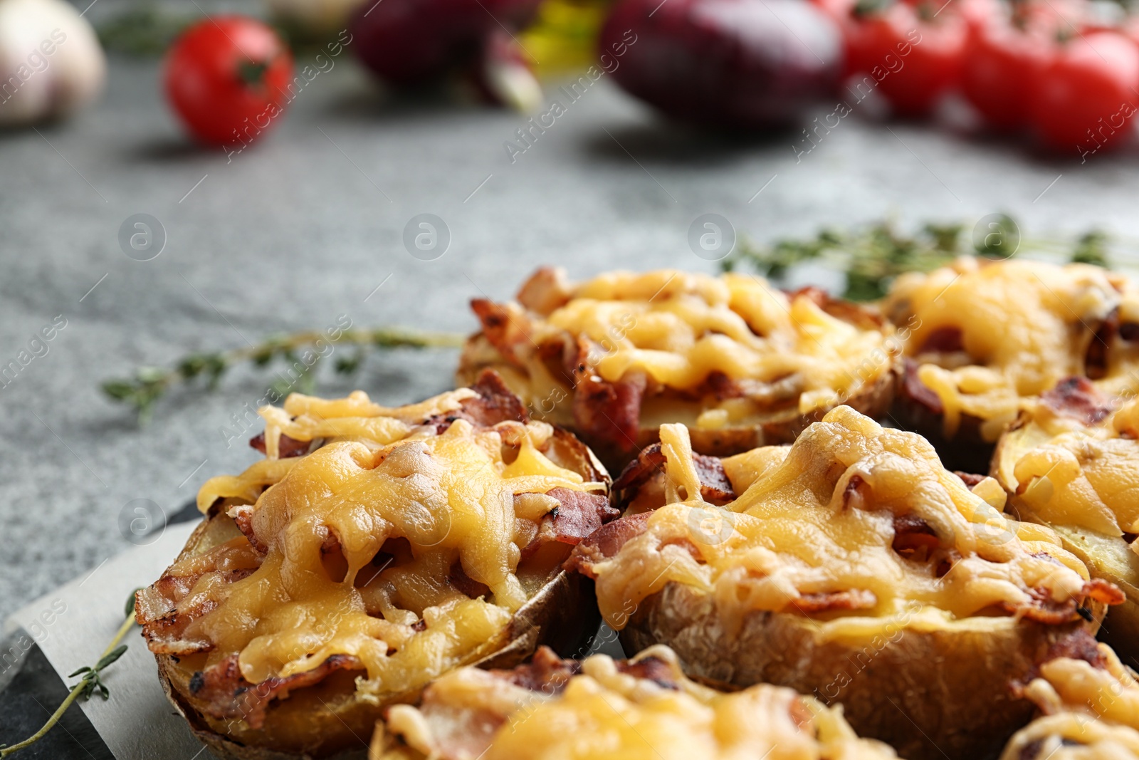 Photo of Baked potatoes with cheese and bacon on table, closeup