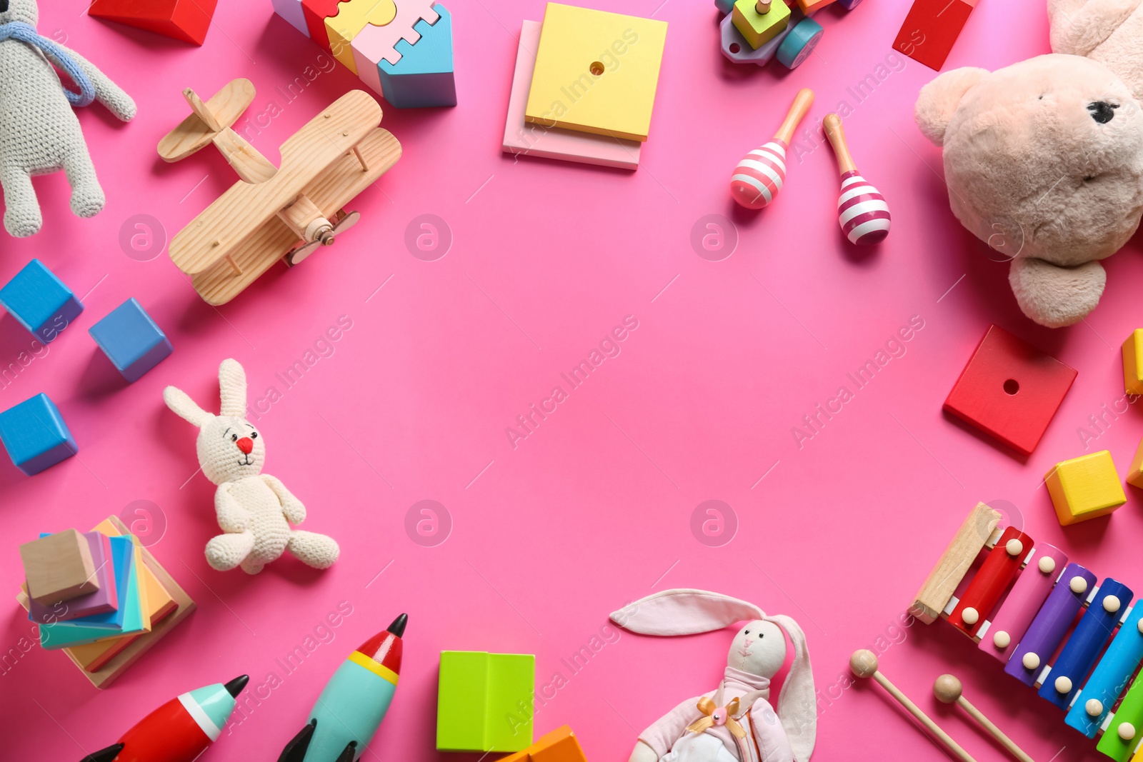 Photo of Frame of different toys on pink background, flat lay. Space for text