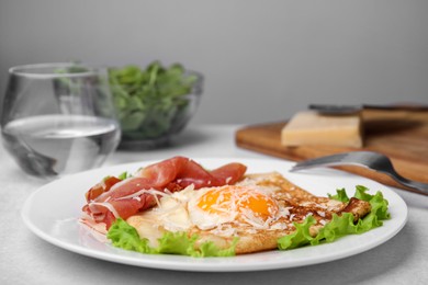 Delicious crepe with egg served on light gray table. Breton galette