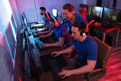 Photo of Young people playing video games on computers indoors. Esports tournament