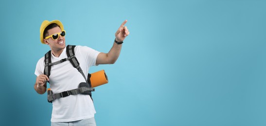 Photo of Male tourist with travel backpack on turquoise background