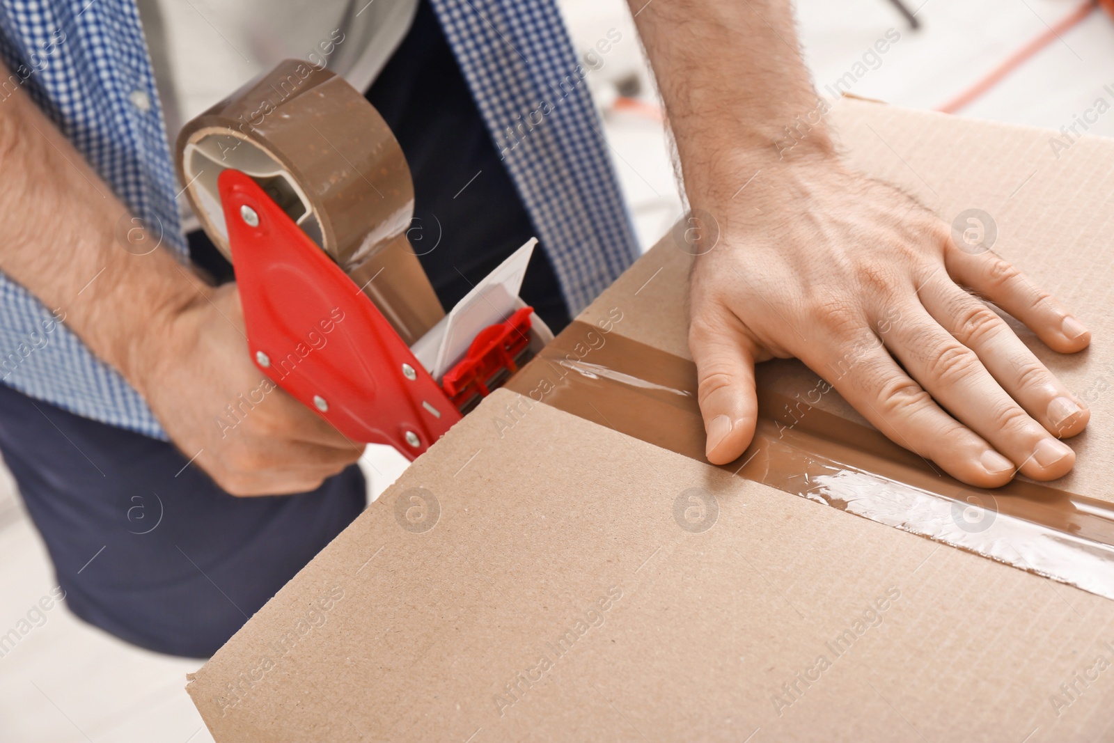 Photo of Man packing cardboard box, closeup. Moving day