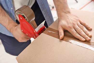 Photo of Man packing cardboard box, closeup. Moving day