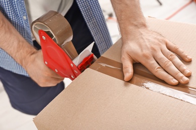 Man packing cardboard box, closeup. Moving day