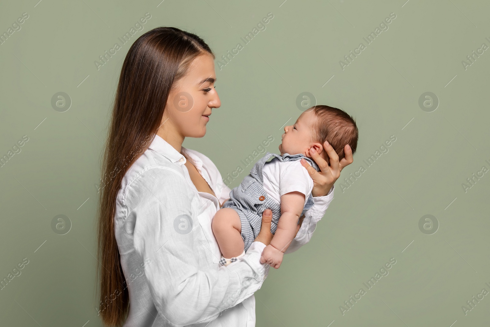 Photo of Mother holding her cute newborn baby on olive background