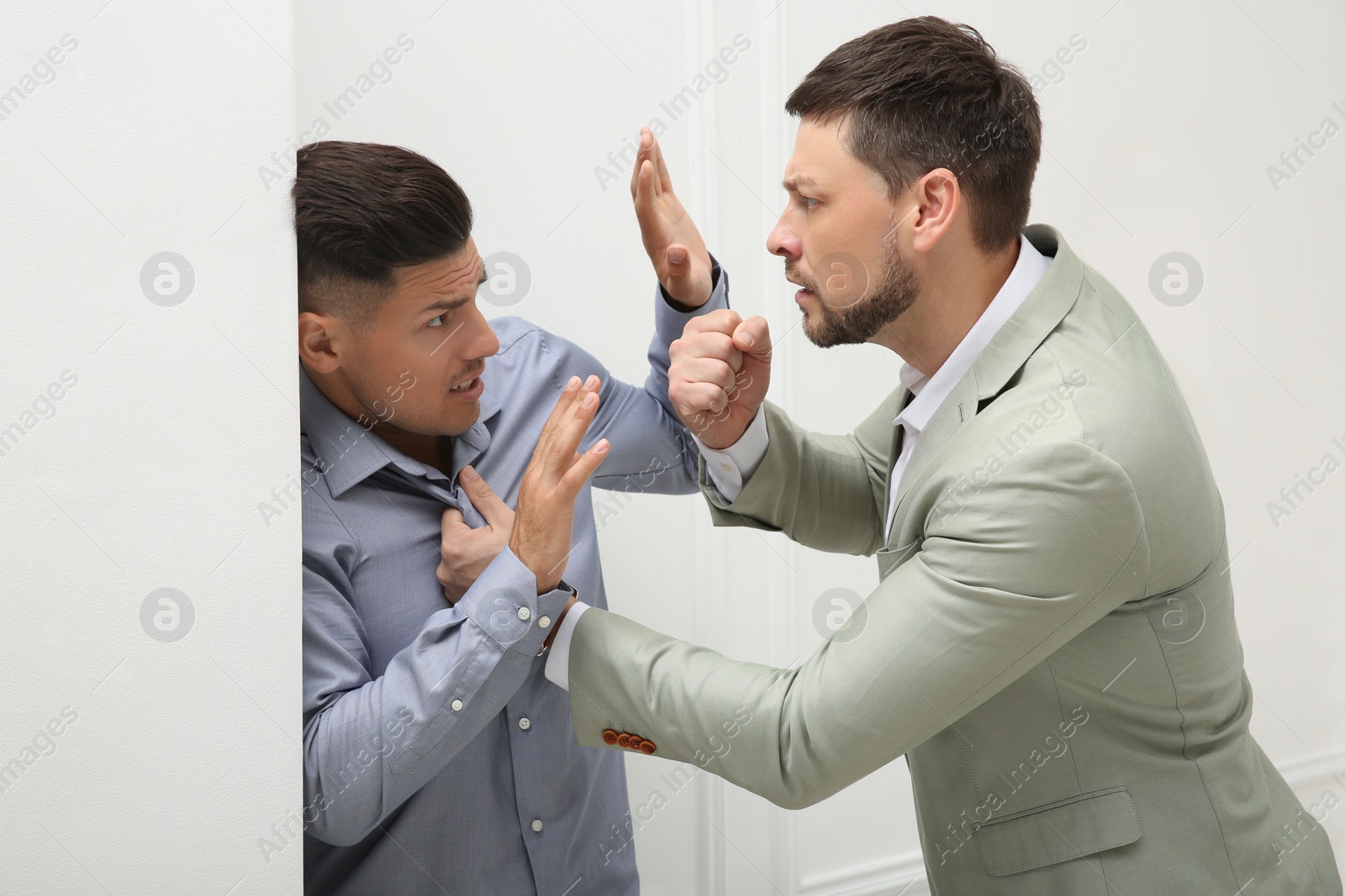 Photo of Emotional colleagues fighting in office. Workplace conflict