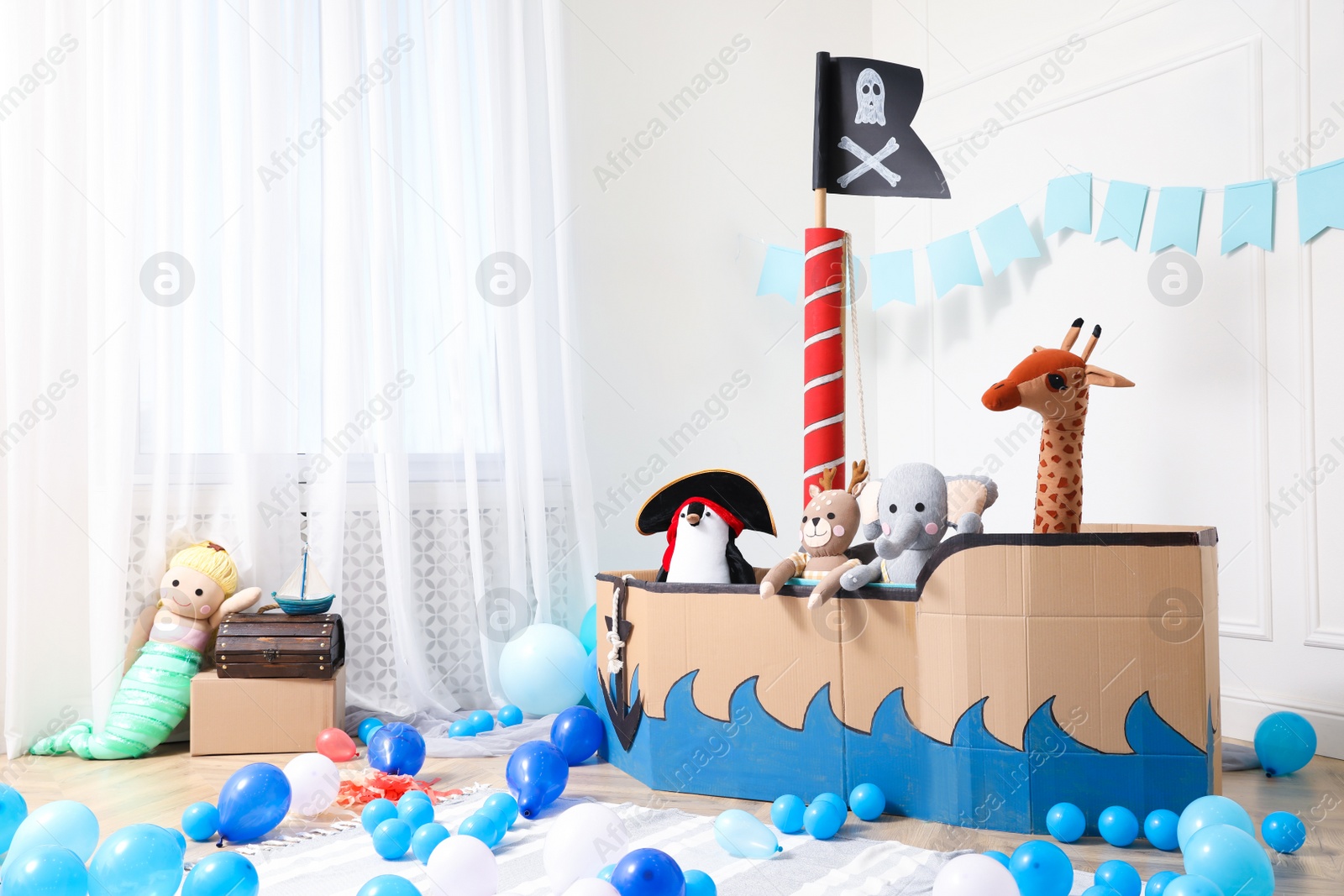 Photo of Child's room interior with pirate cardboard ship and toys