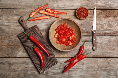 Flat lay composition with chili peppers on wooden background