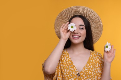 Beautiful woman with spring flowers in hands on yellow background, space for text