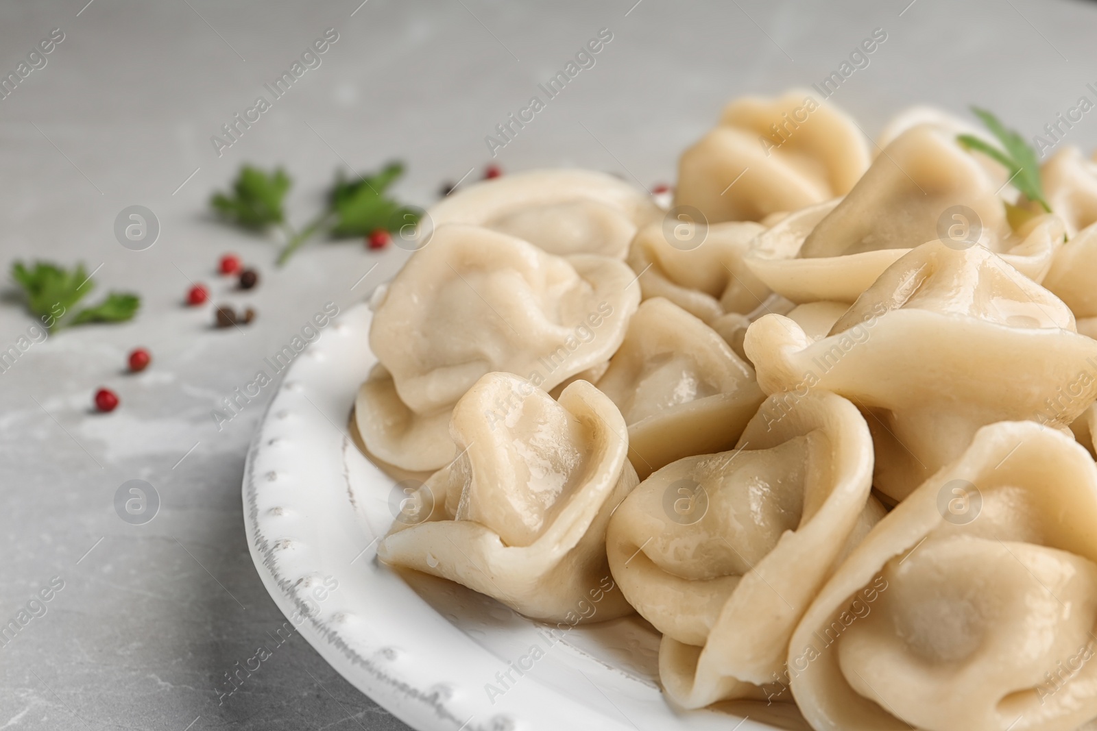 Photo of Tasty dumplings with parsley on plate, closeup view