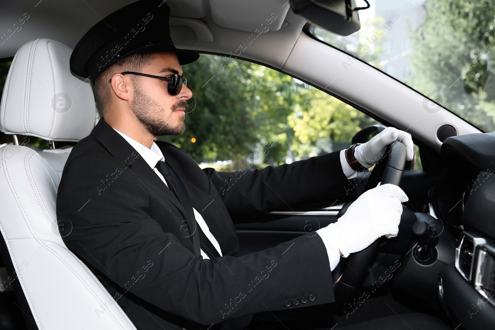 Photo of Young handsome driver in luxury car. Chauffeur service