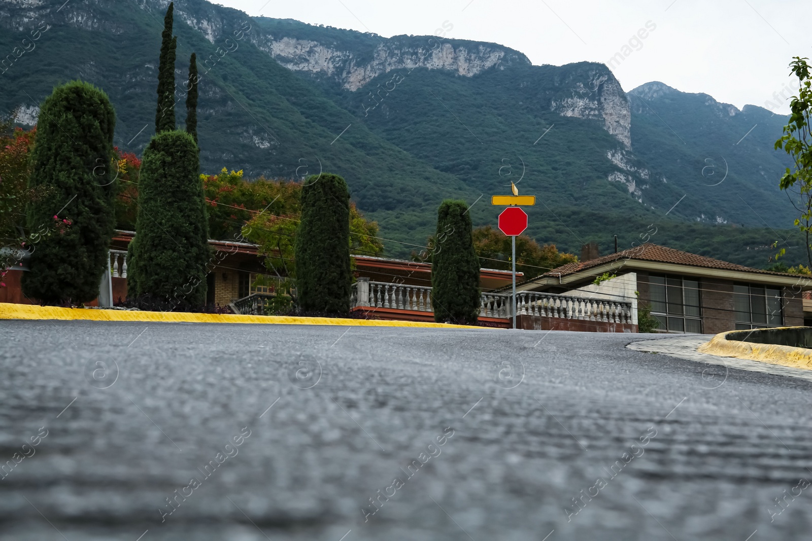 Photo of Picturesque view of road and green trees near mountains