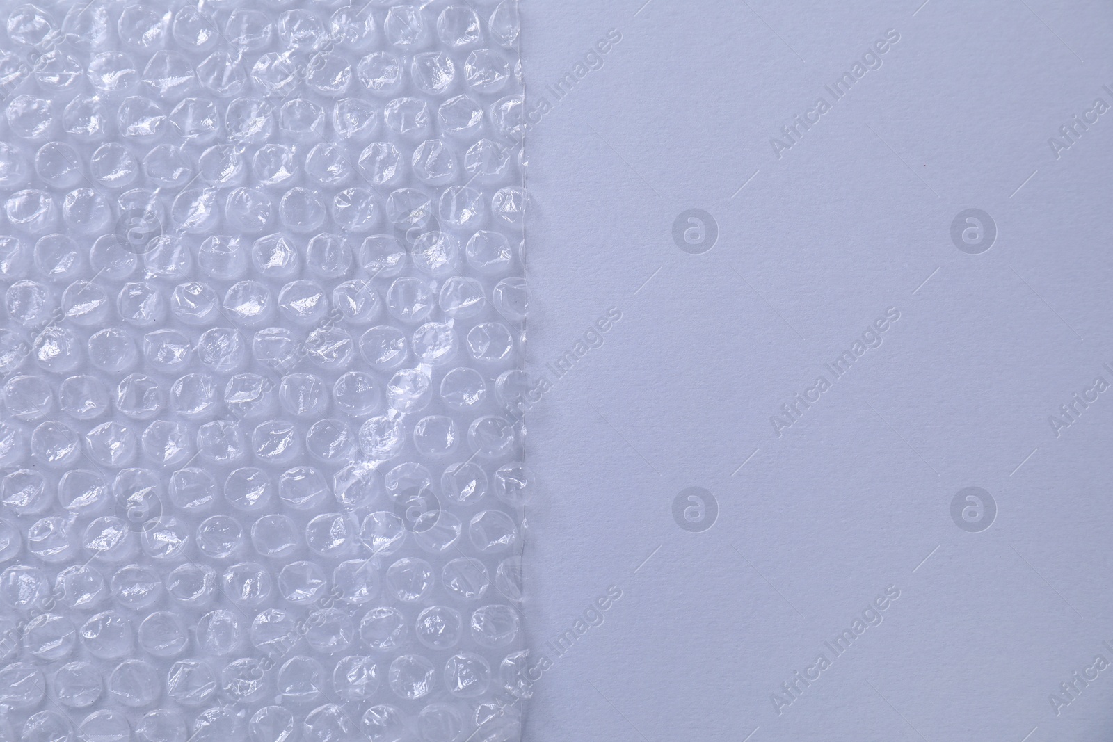 Photo of Transparent bubble wrap on gray background, top view. Space for text