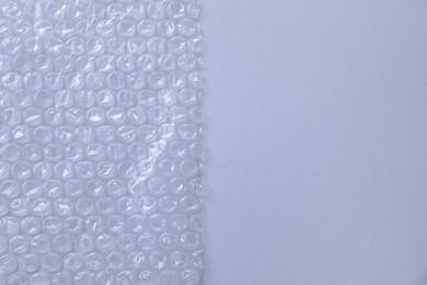 Transparent bubble wrap on gray background, top view. Space for text