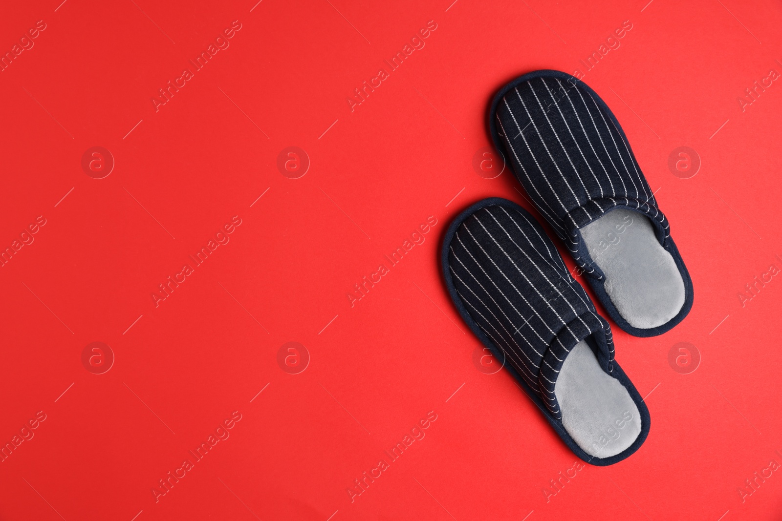 Photo of Pair of stylish slippers on red background, top view. Space for text