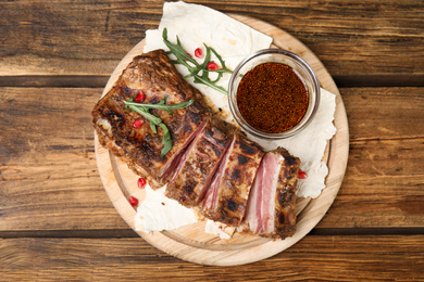 Photo of Delicious grilled ribs served on wooden table, top view