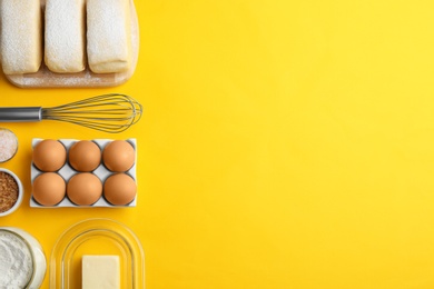 Puff pastry dough and ingredients on yellow background, flat lay. Space for text