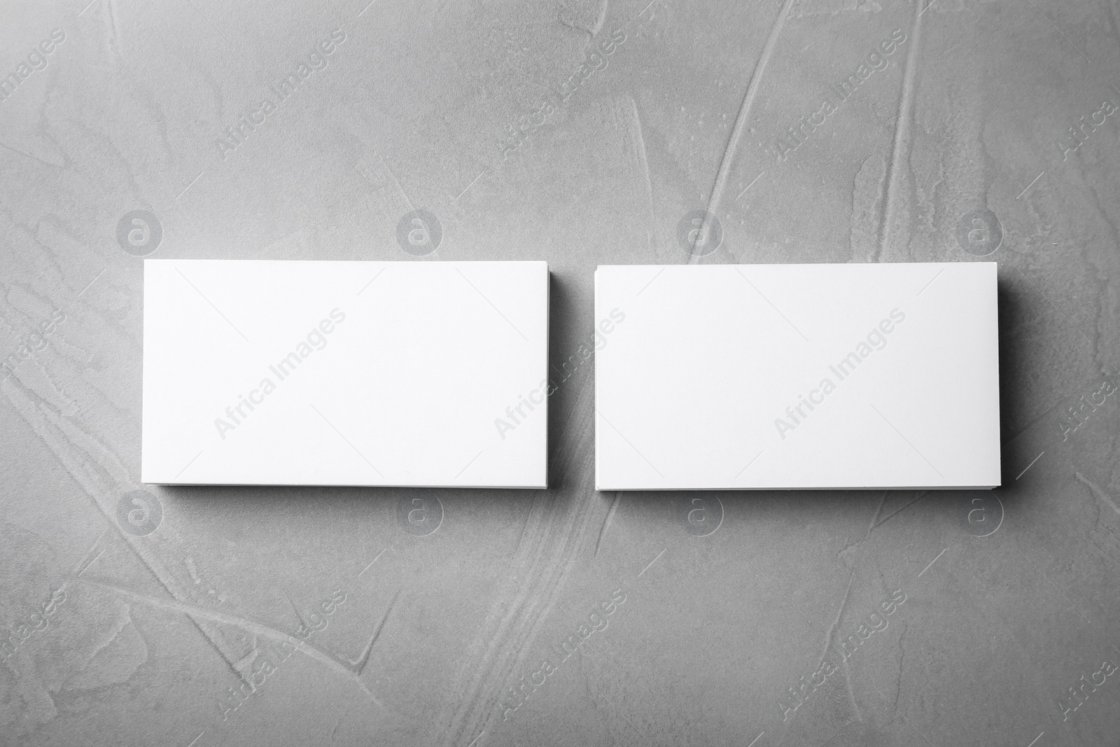 Photo of Blank business cards on light grey stone background, flat lay. Mock up for design