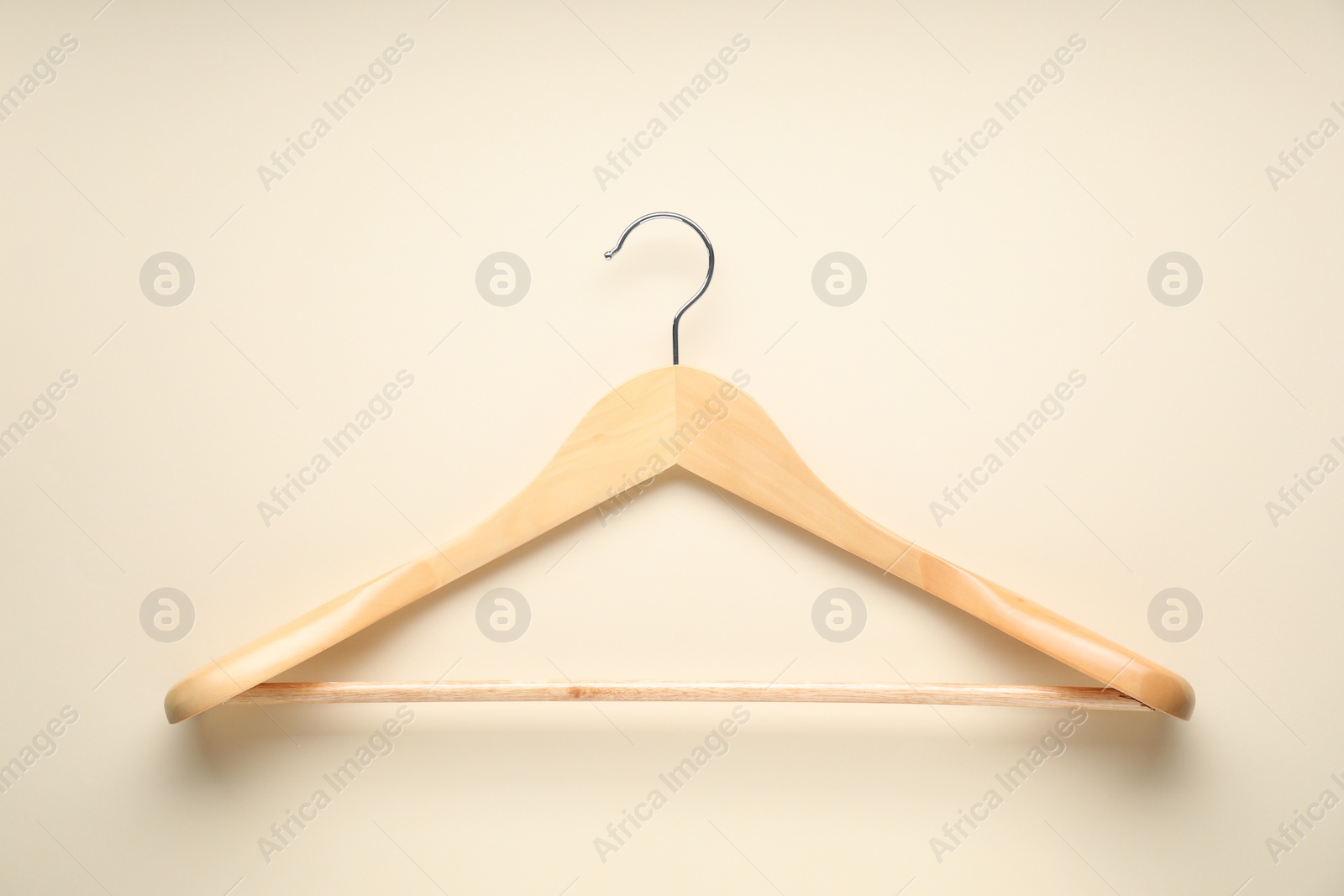 Photo of Empty wooden hanger on beige background, top view