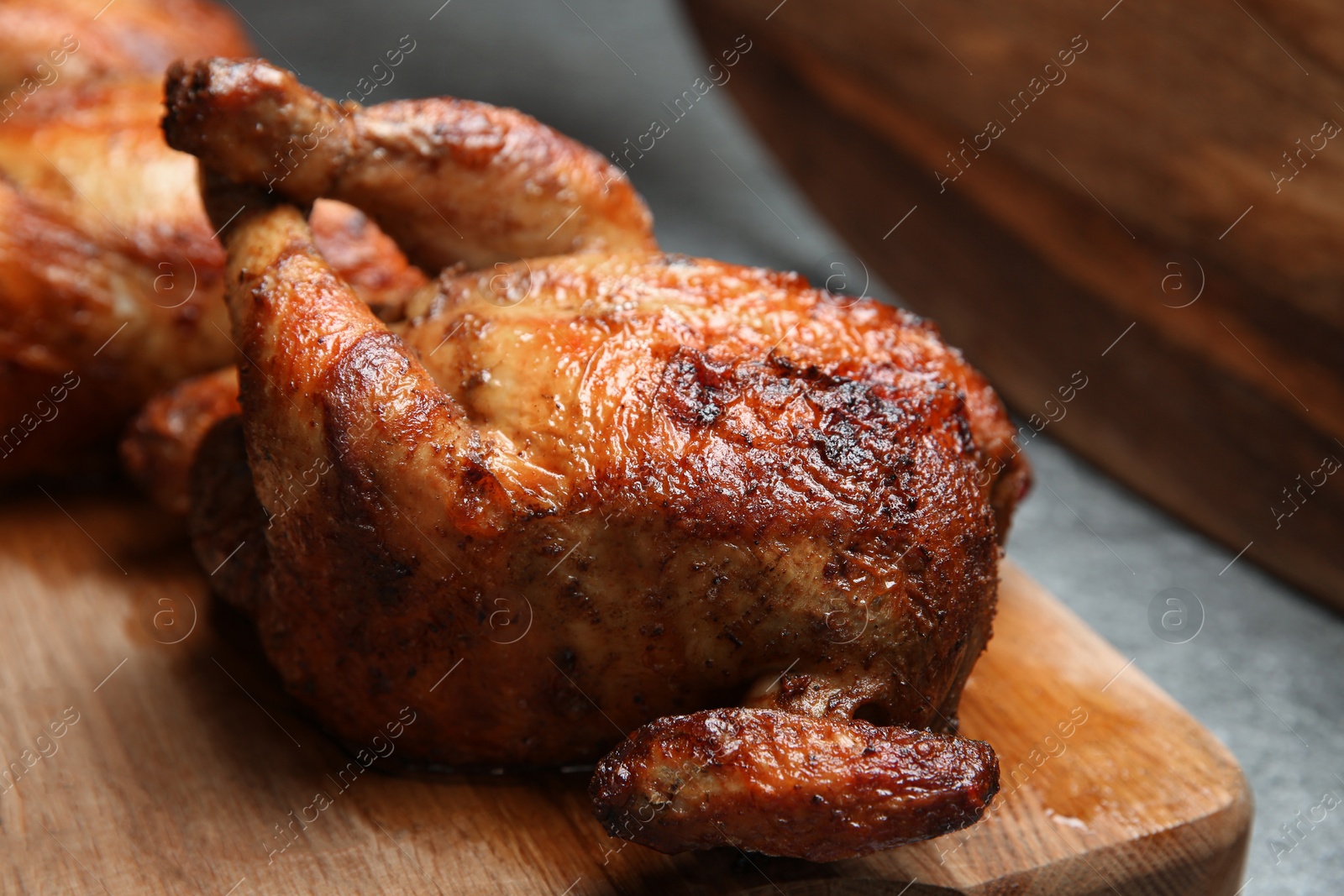 Photo of Delicious grilled whole chickens on grey table, closeup