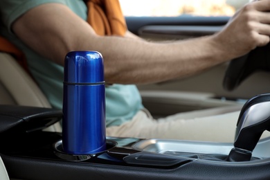 Blue thermos in holder inside of car