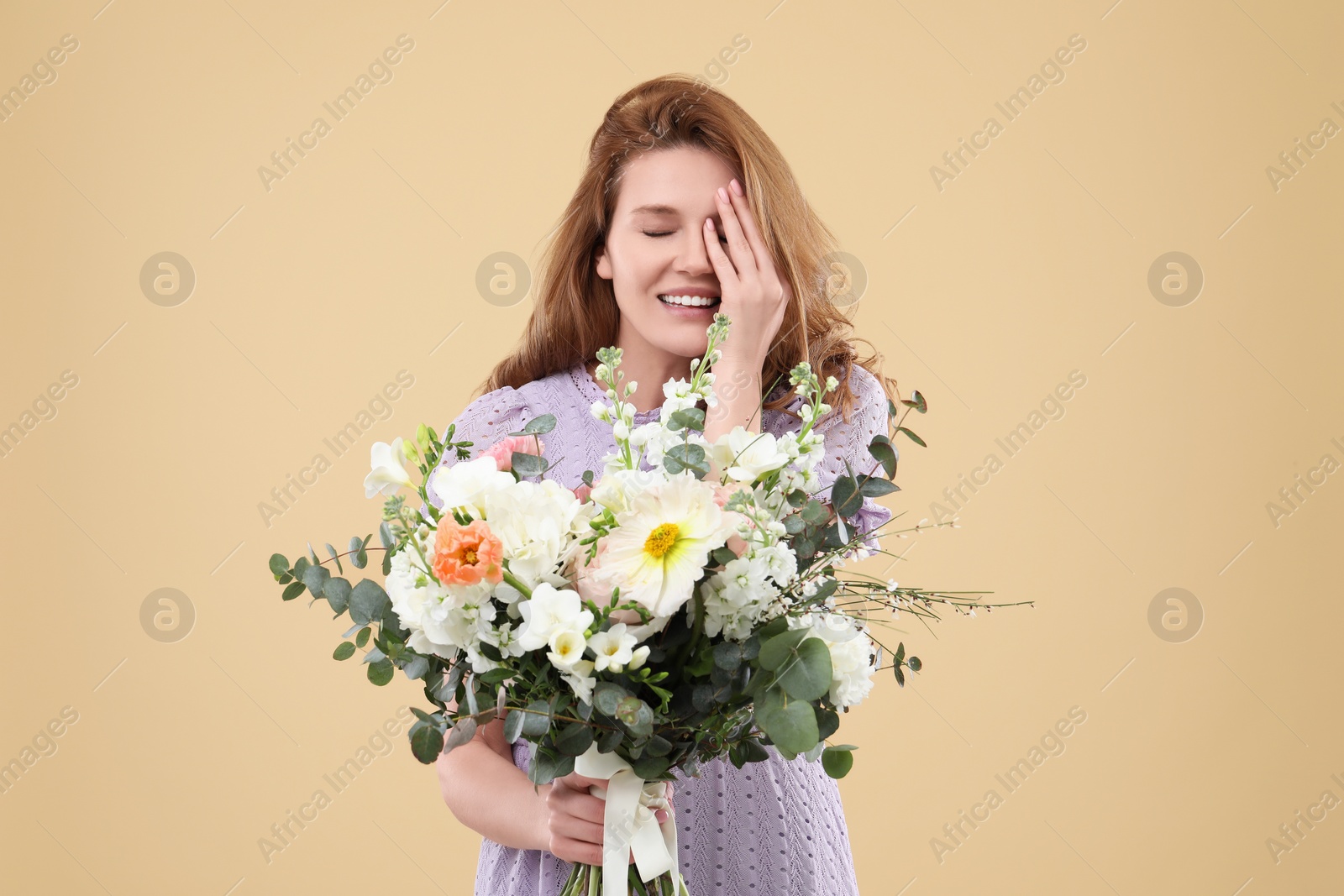 Photo of Beautiful woman with bouquet of flowers on beige background