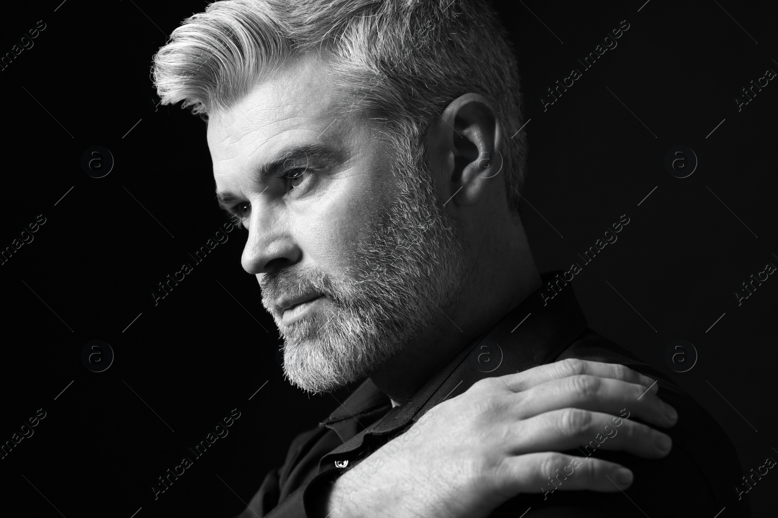 Photo of Portrait of handsome man on dark background. Black and white effect
