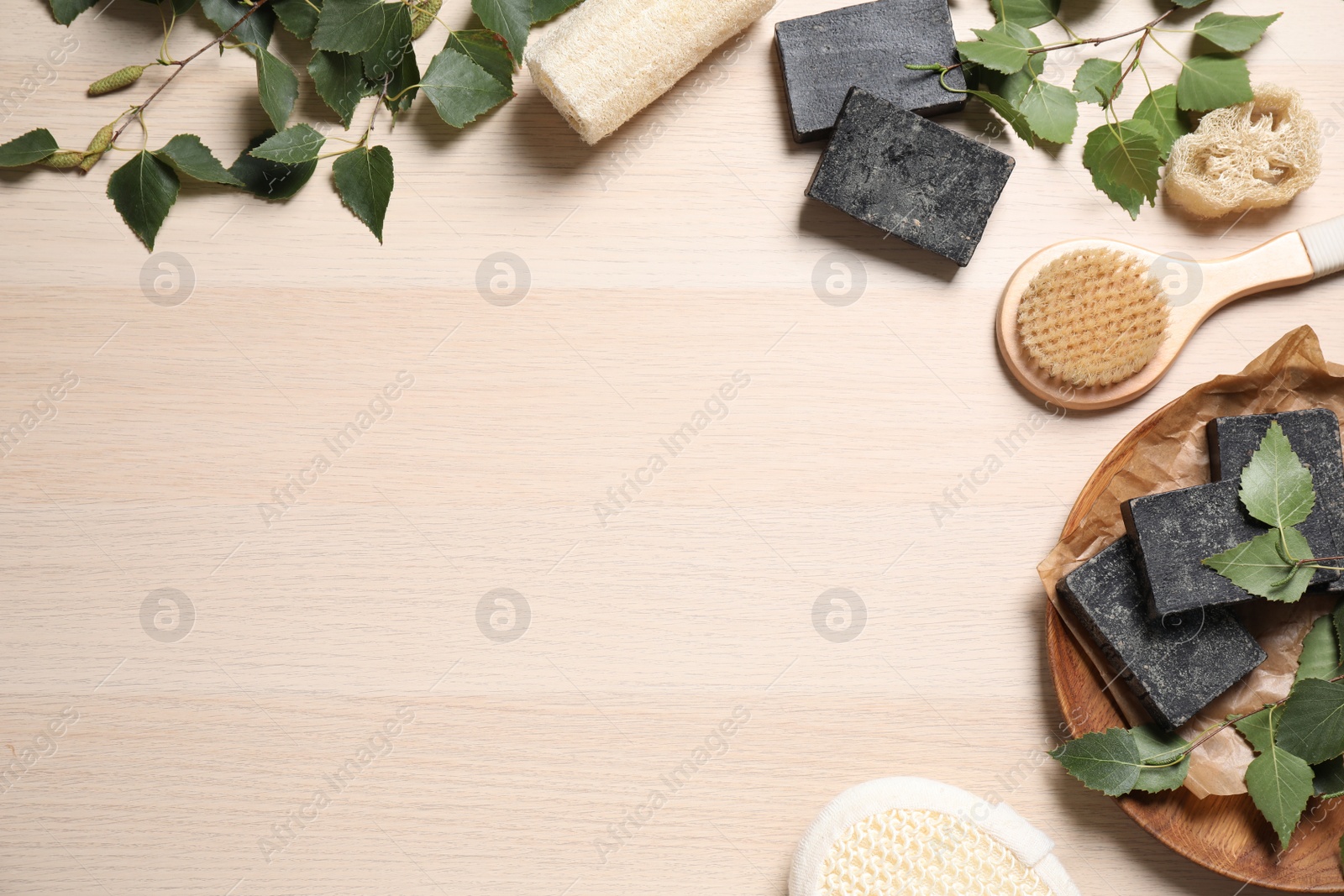 Photo of Flat lay composition with natural tar soap on wooden table. Space for text