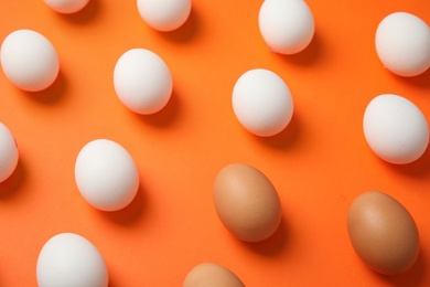 Photo of Many raw chicken eggs on color background