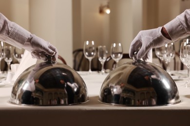 Men setting table in restaurant, closeup. Professional butler courses