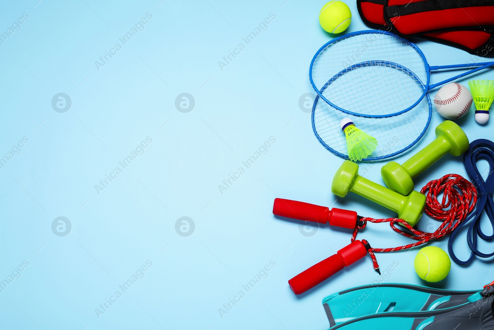 Photo of Set of different sports equipment on light blue background, flat lay. Space for text