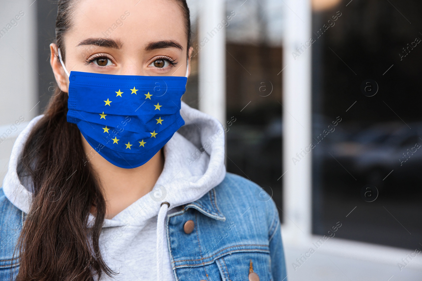 Image of Woman wearing medical mask with European Union flag, outdoors. Coronavirus outbreak in Europe