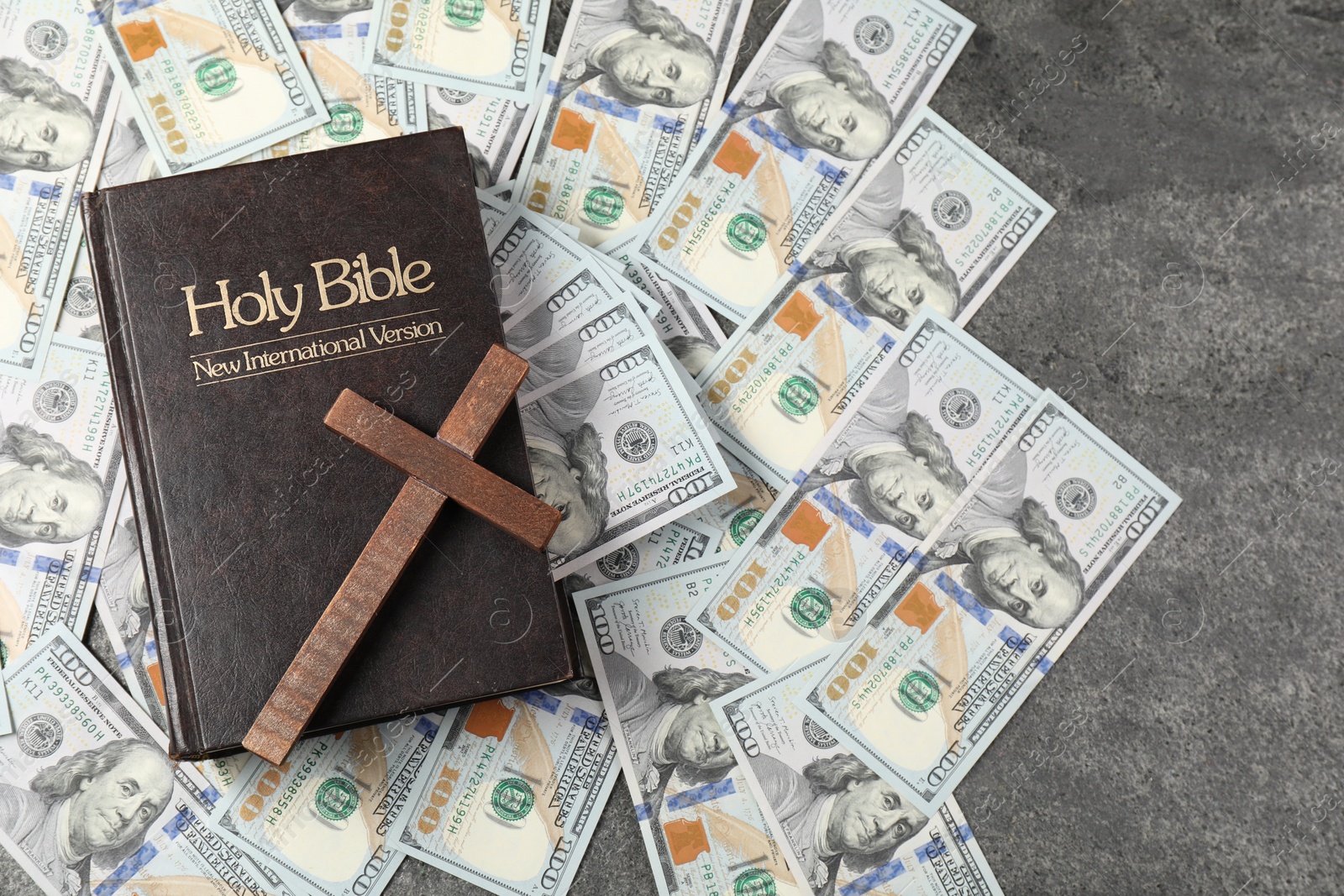 Photo of Holy Bible, cross and money on grey table, top view