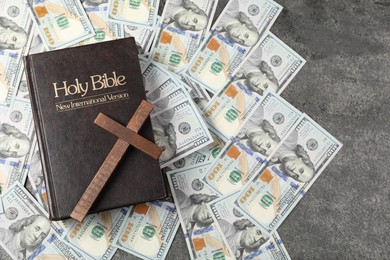 Holy Bible, cross and money on grey table, top view