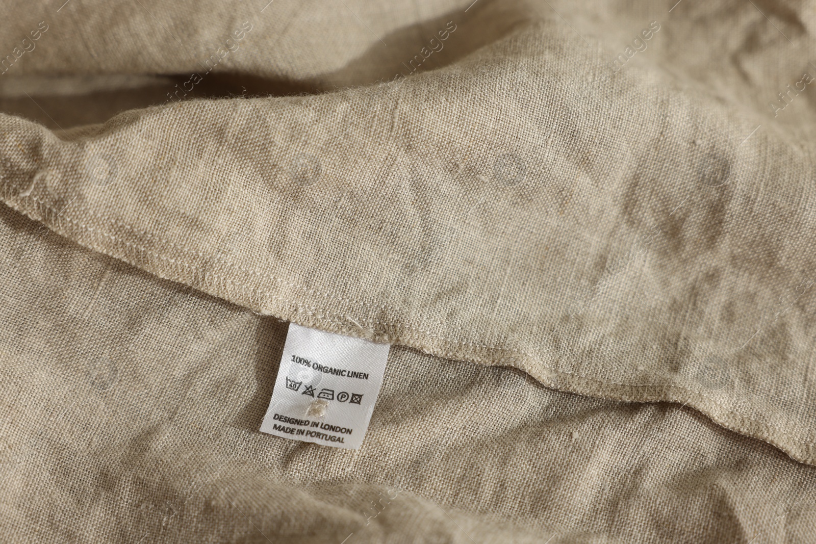 Photo of Clothing label on beige garment, closeup view